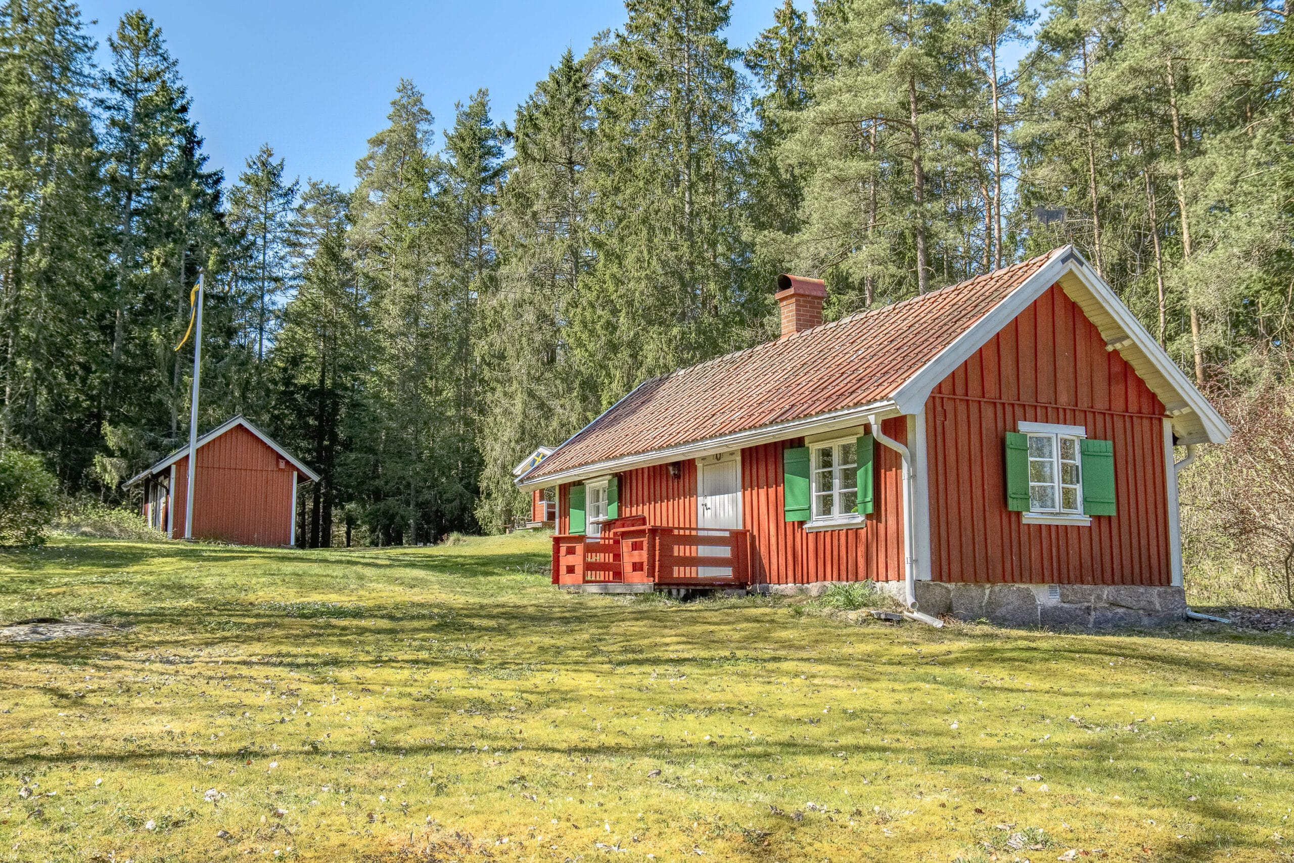 Röd stuga i dalsländskt landskap